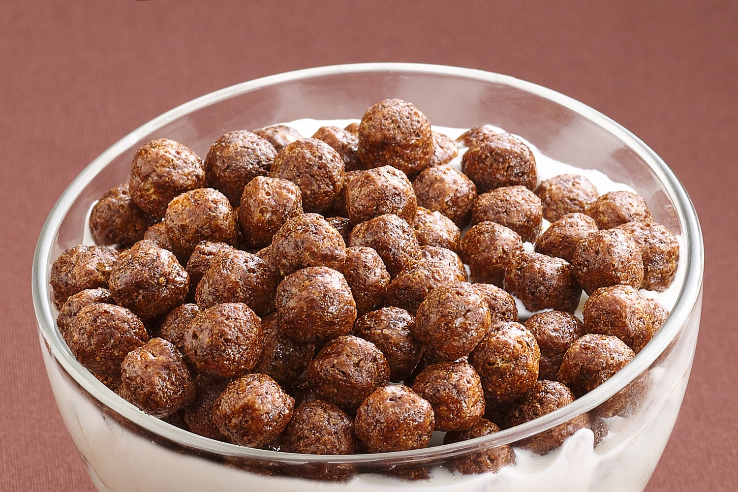 A glass bowl full of Cocoa Puffs cereal